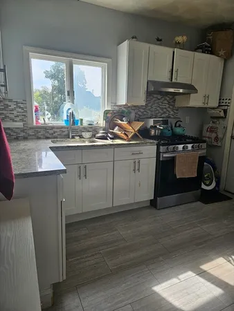 a kitchen with stainless steel appliances granite countertop a sink stove and cabinets