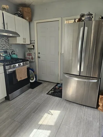 a kitchen with a refrigerator a stove and wooden cabinets