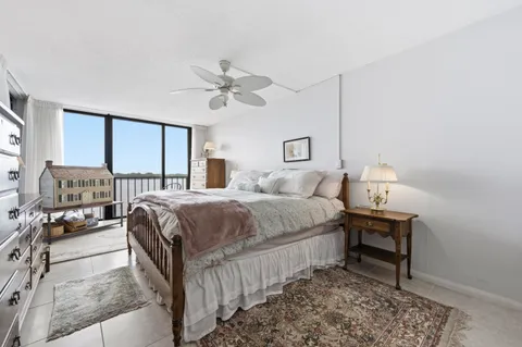 a bedroom with a bed a chair and a chandelier