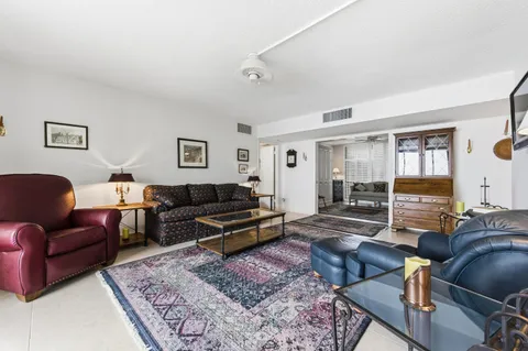 a living room with furniture a rug and a window