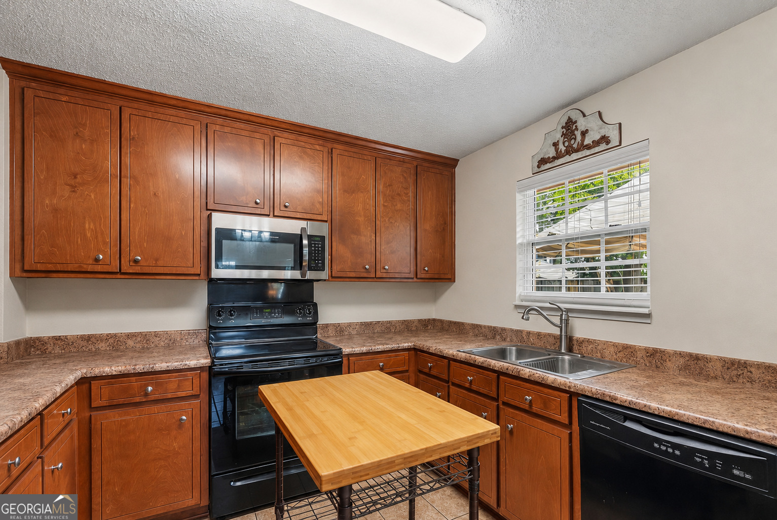 138 Brookfair Lane Leesburg, GA 31763 - Photo 12 of 30 a kitchen with kitchen island granite countertop wooden cabinets a sink and a stove