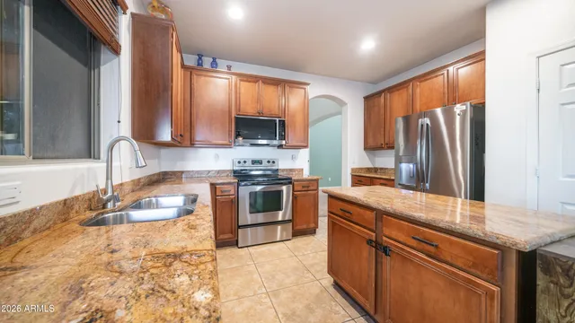 a kitchen with stainless steel appliances granite countertop a sink stove and refrigerator