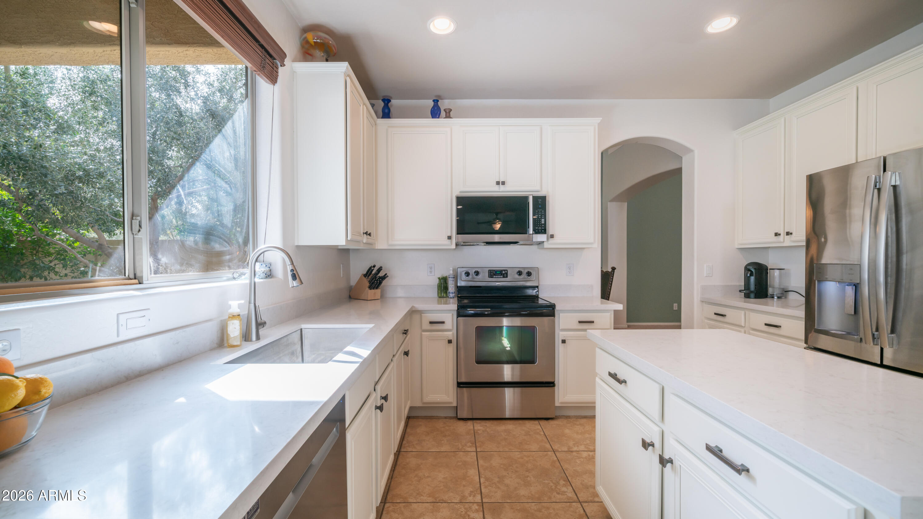 7609 South 18th Way Phoenix, AZ 85042 - Photo 2 of 32 a kitchen with a sink a counter top space stainless steel appliances a large window and cabinets