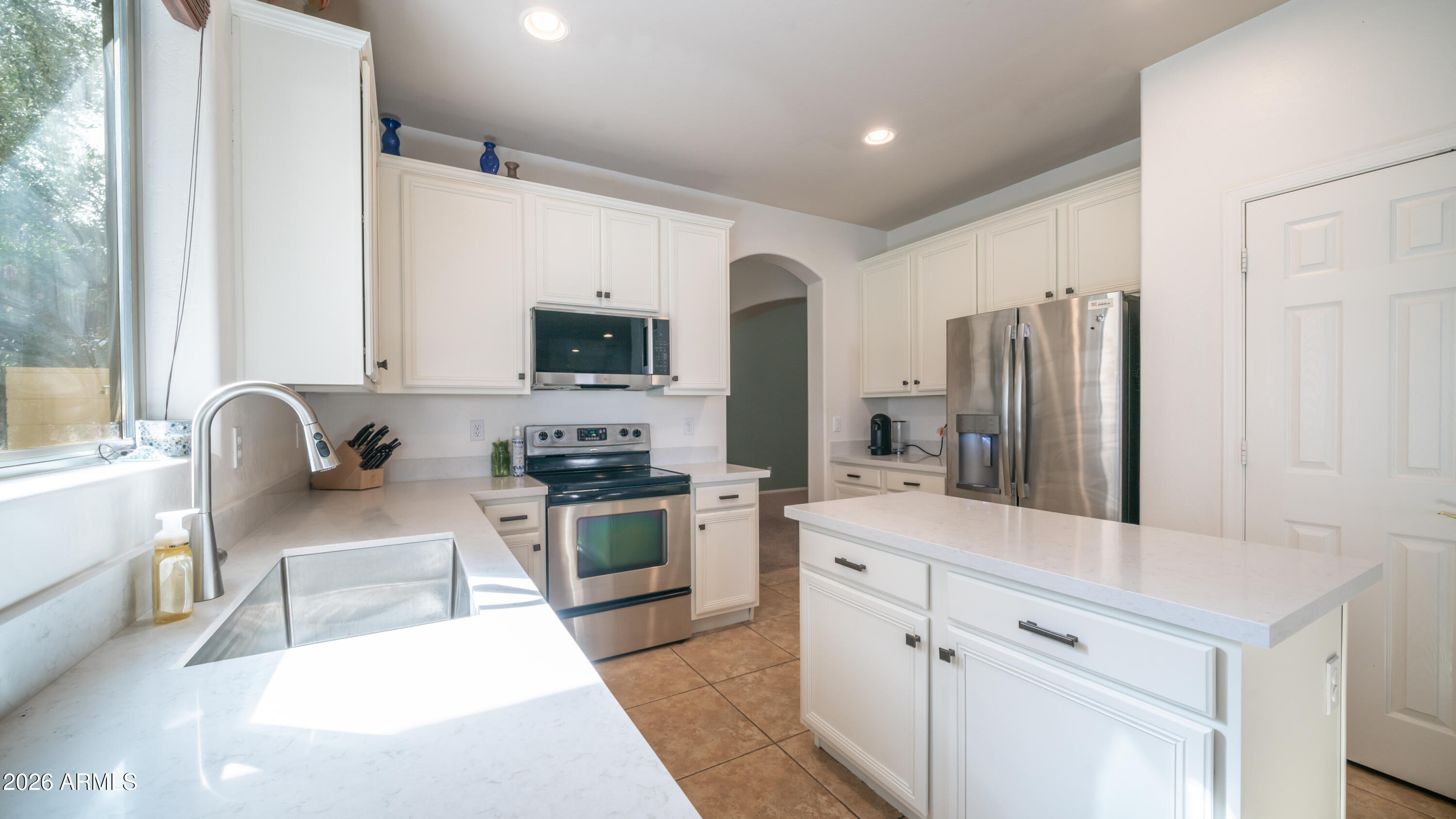 7609 South 18th Way Phoenix, AZ 85042 - Photo 3 of 32 a kitchen with stainless steel appliances granite countertop a refrigerator stove microwave and sink