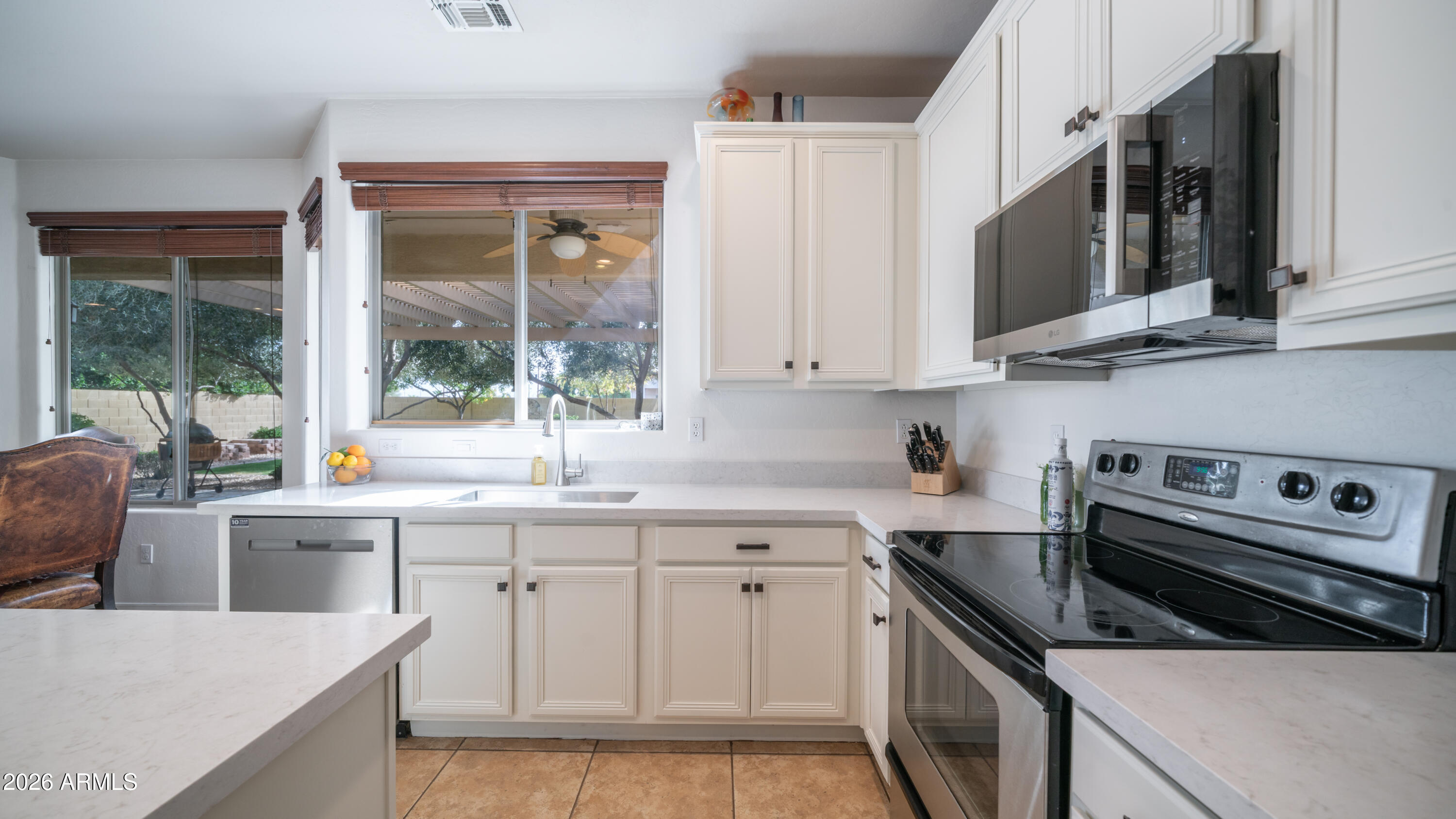 7609 South 18th Way Phoenix, AZ 85042 - Photo 5 of 32 a kitchen with stainless steel appliances a stove sink and cabinets