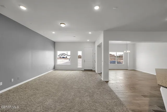 a view of a hallway with wooden floor and windows