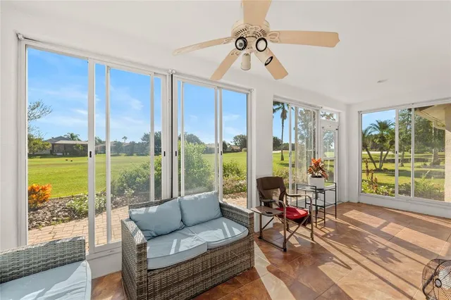 a living room filled with furniture and floor to ceiling windows