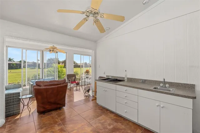 a living room with kitchen island granite countertop furniture a large window and a sink