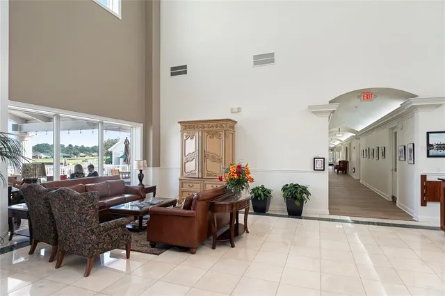 a living room with furniture potted plant floor to ceiling windows and a living room view