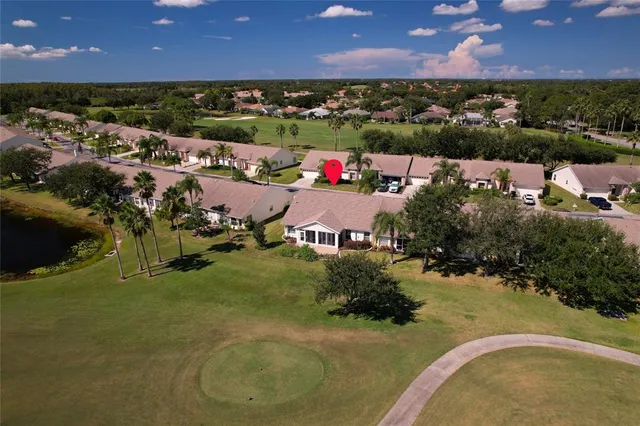 an aerial view of residential houses with outdoor space and trees