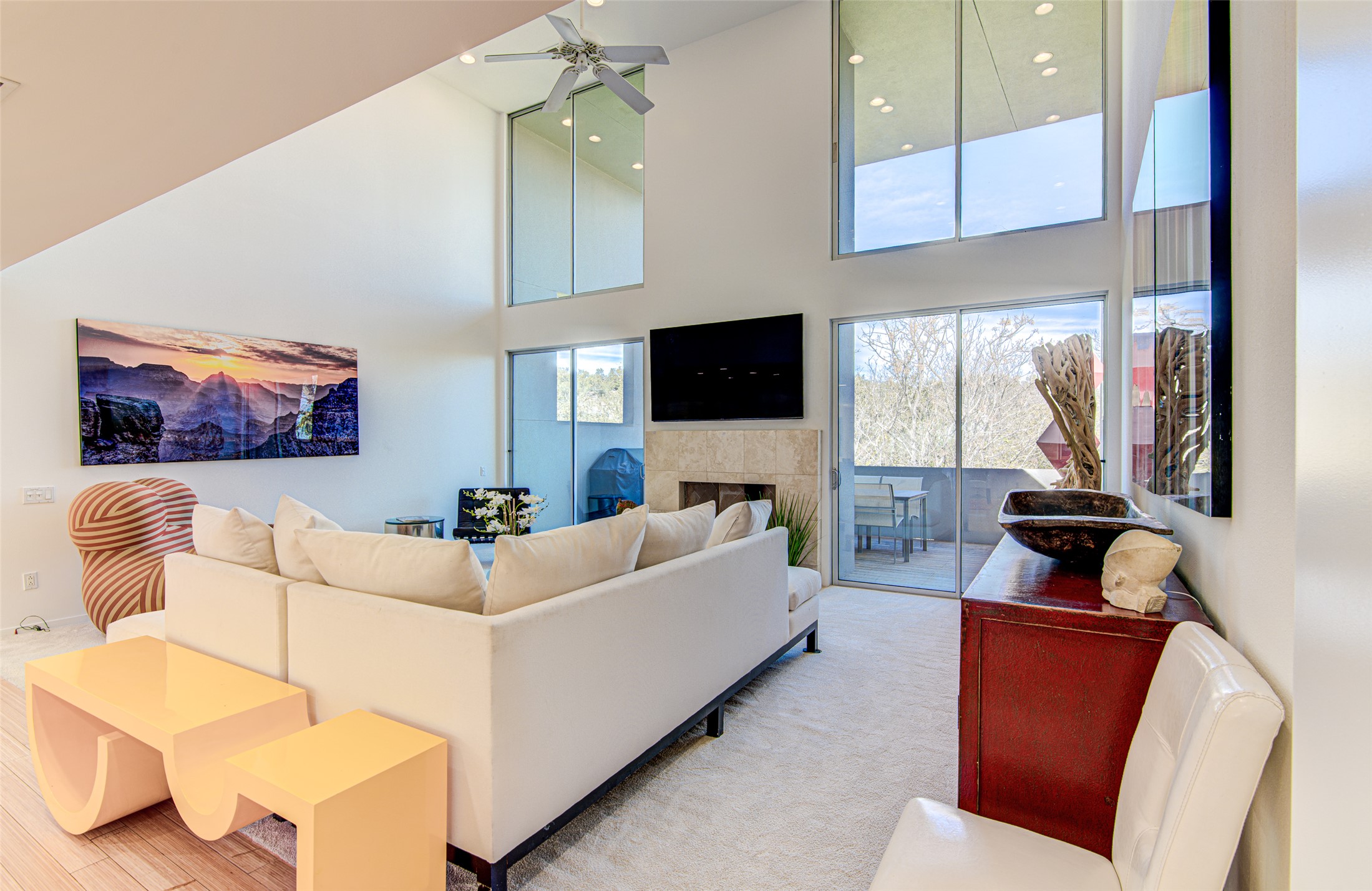 9707 Timber Ridge Pass Austin, TX 78733 - Photo 4 of 18 Towering ceilings and double-height windows define this open living space anchored by a fireplace.