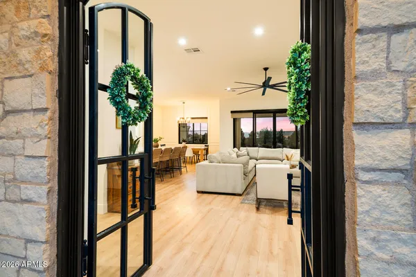 a large white kitchen with stainless steel appliances kitchen island a stove a refrigerator a oven and white cabinets with wooden floor