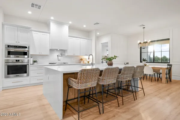 a dining room with furniture a chandelier and wooden floor