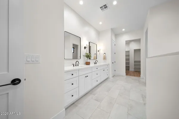 a bathroom with a double vanity sink toilet mirror and shower