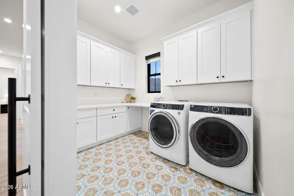 a view of patio with table and chairs under an umbrella with a barbeque