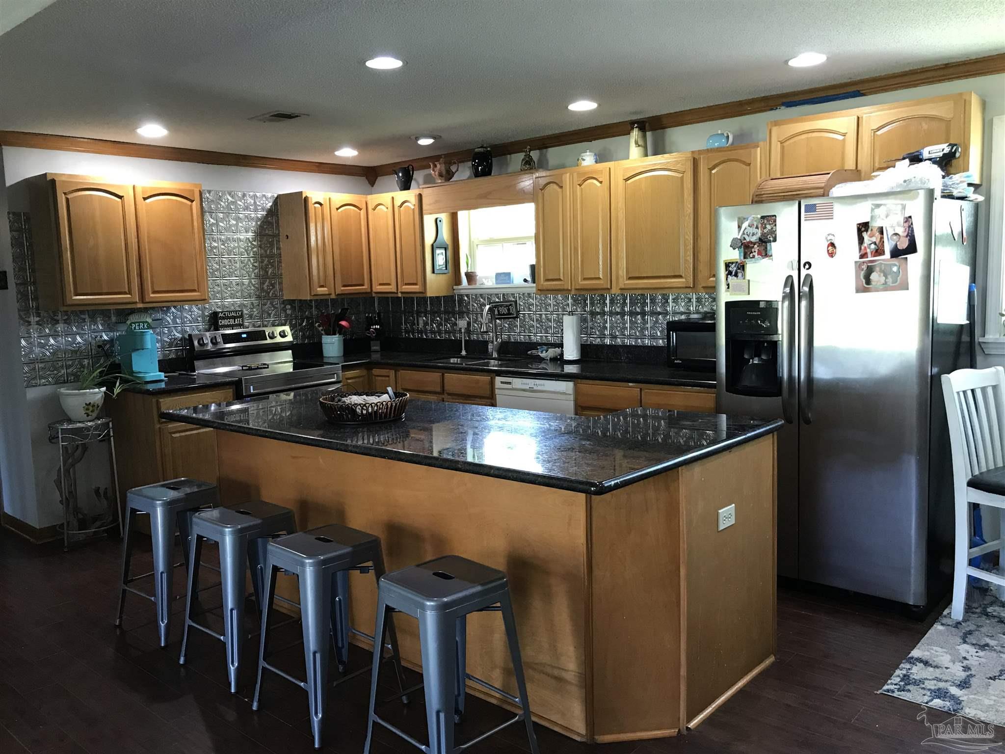 2529 Molino Road Molino, FL 32577 - Photo 12 of 43 a kitchen with stainless steel appliances granite countertop a sink refrigerator and microwave