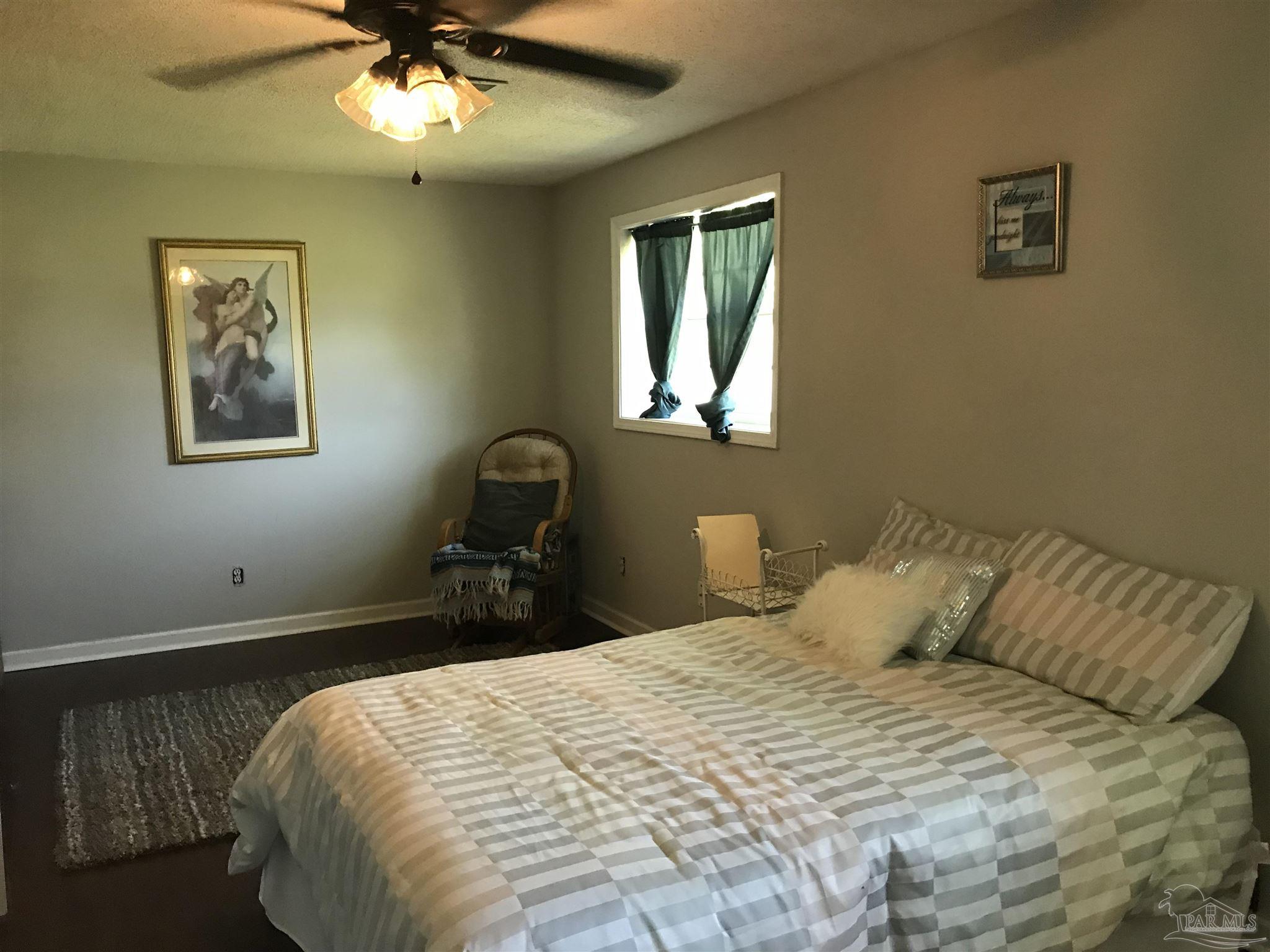 2529 Molino Road Molino, FL 32577 - Photo 23 of 43 a bedroom with a bed and a chandelier