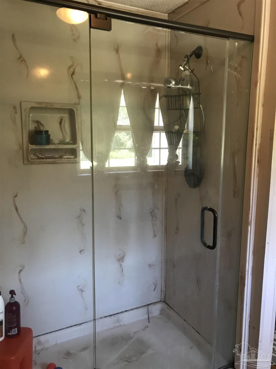 2529 Molino Road Molino, FL 32577 - Photo 31 of 43 a bathroom with a glass shower door and mirror