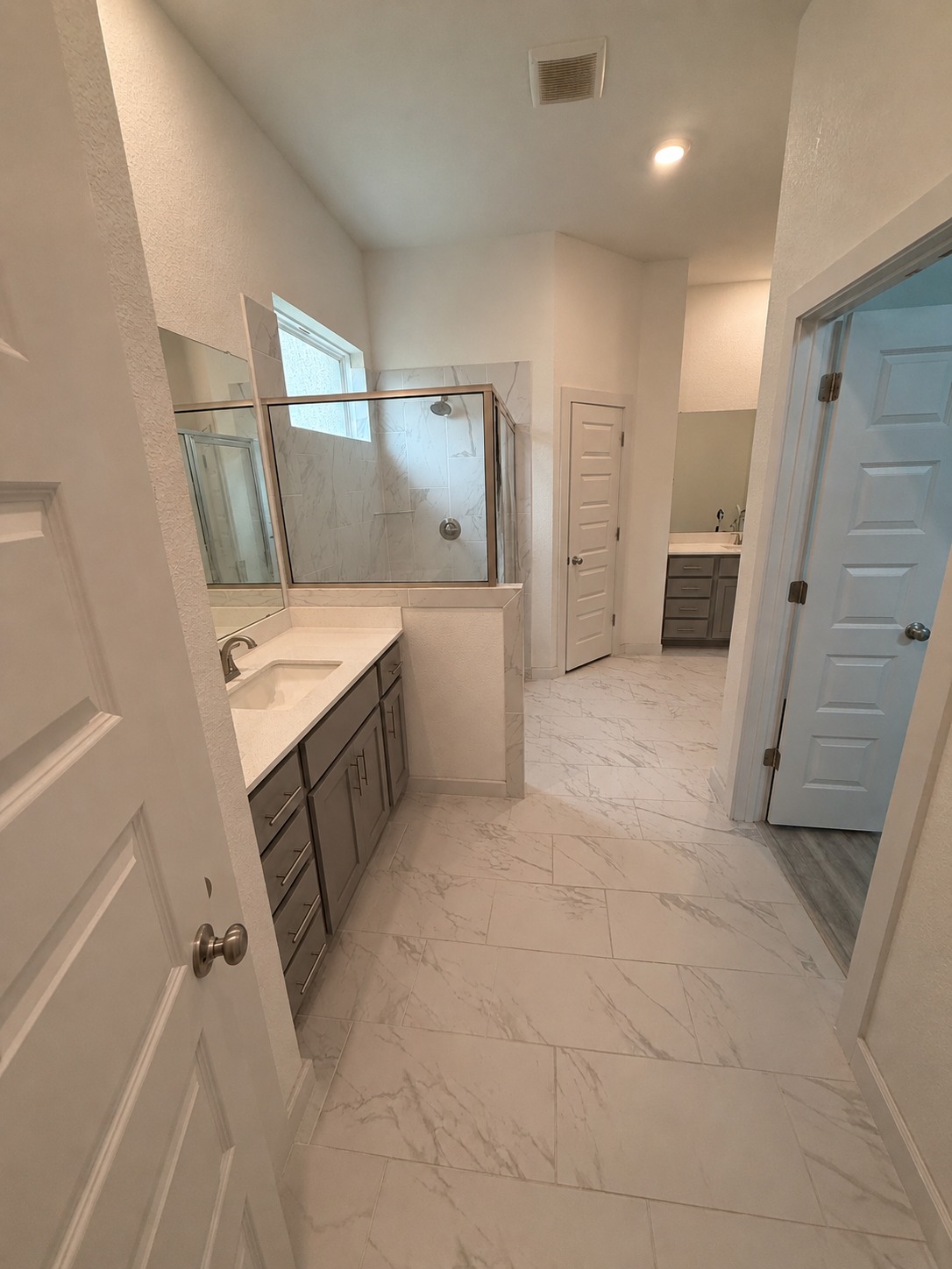 1213 Bryson Rdg Trail Leander, TX 78641 - Photo 10 of 16 Clean, contemporary design defines this spacious bathroom, featuring dual vanities and an inviting glass-enclosed shower.