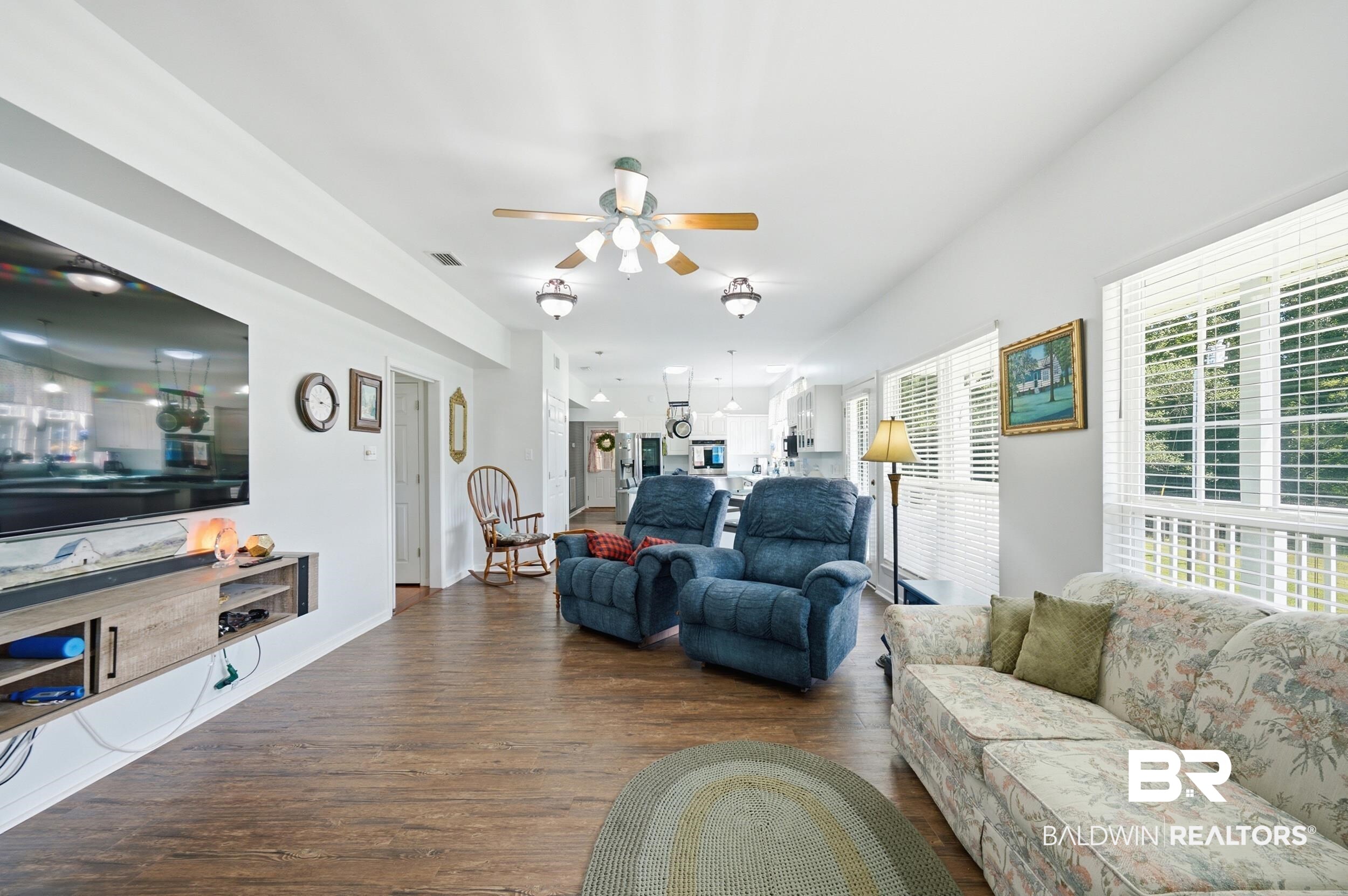 15855 Calvin Richerson Road Bay Minette, AL 36507 - Photo 34 of 83 Open-concept living area featuring wood-finish flooring, white walls, and multiple windows with horizontal blinds