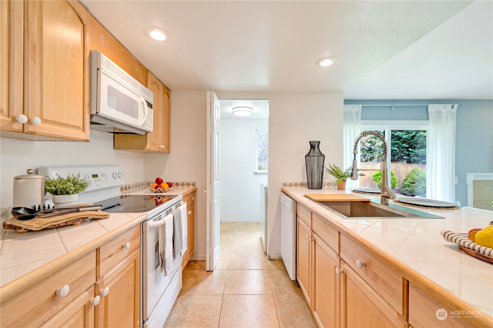 14401 Southeast Petrovitsky Road, Unit B101 Renton, WA 98058 - Photo 14 of 22 a kitchen with a sink stove and cabinets
