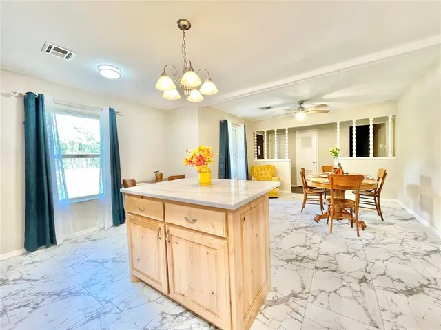 a view of a dining room and kitchen with a chandelier