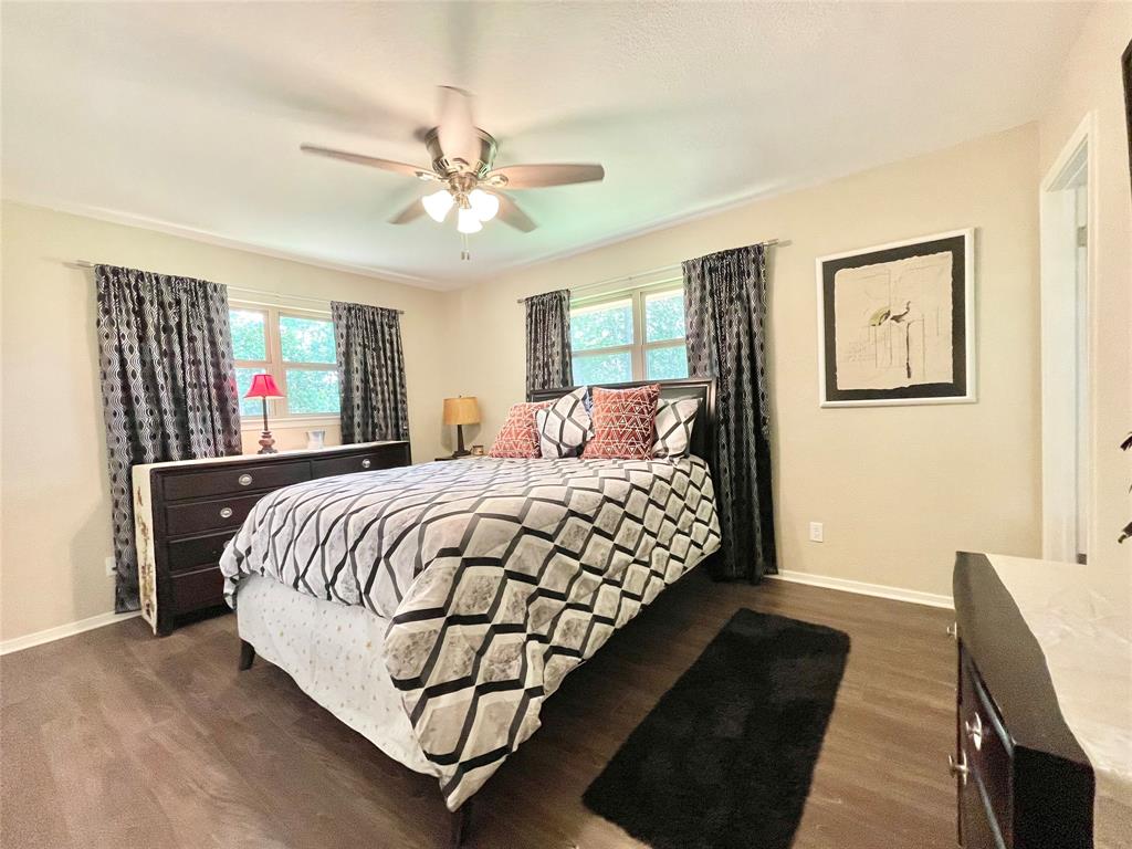 945 Brickyard Road West, TX 76691 - Photo 17 of 25 a bedroom with a large bed and a chandelier