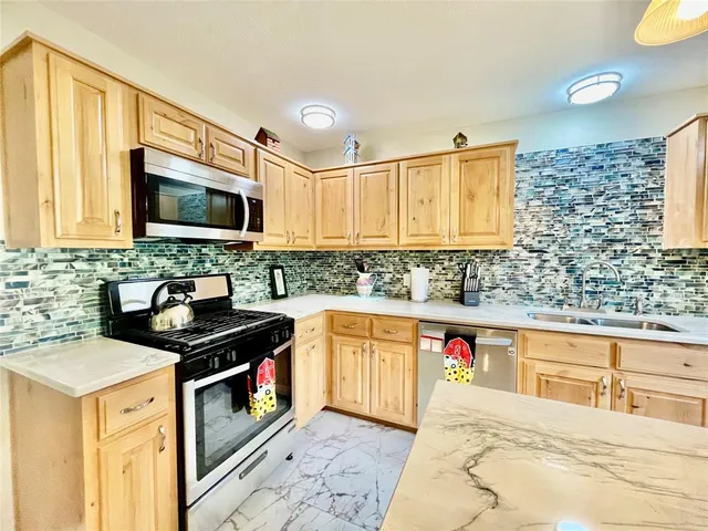a kitchen with stainless steel appliances granite countertop a sink stove and microwave