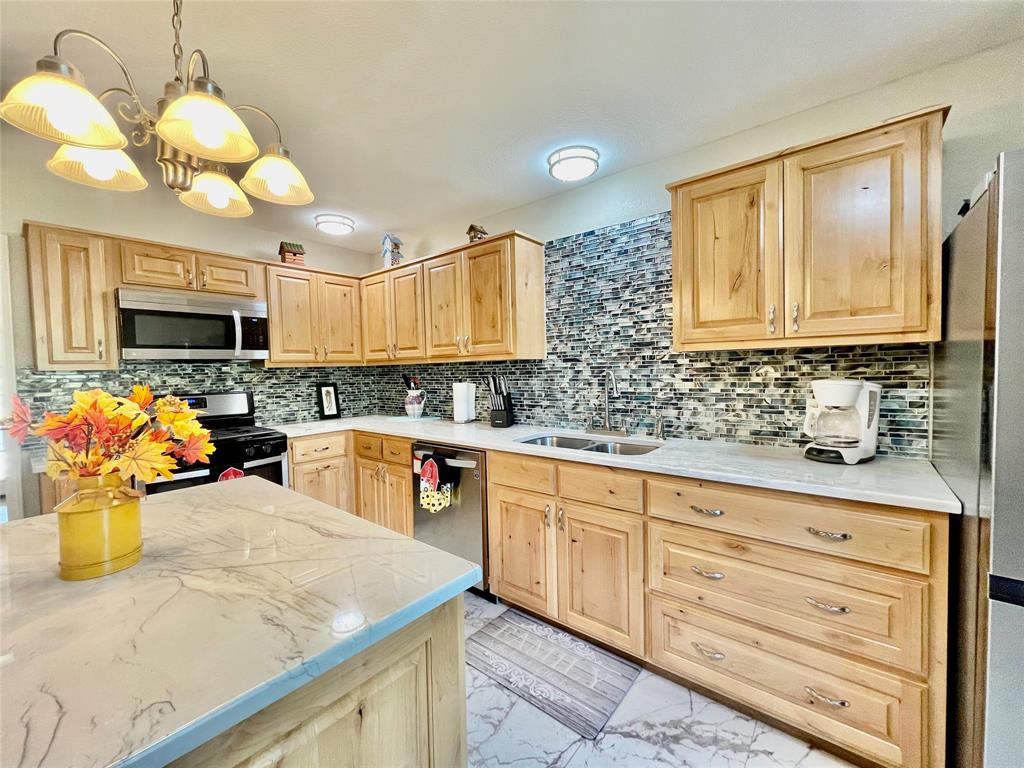 945 Brickyard Road West, TX 76691 - Photo 10 of 25 a kitchen with stainless steel appliances granite countertop a sink a stove and a microwave