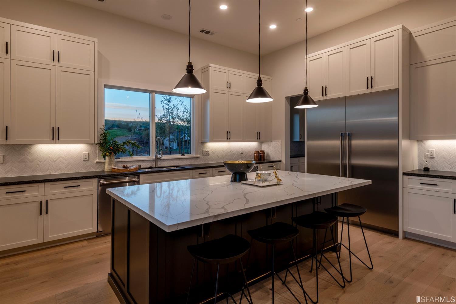 5 Winding Oaks Drive Pleasanton, CA 94566 - Photo 27 of 72 a kitchen with stainless steel appliances granite countertop a kitchen island a table and chairs in it
