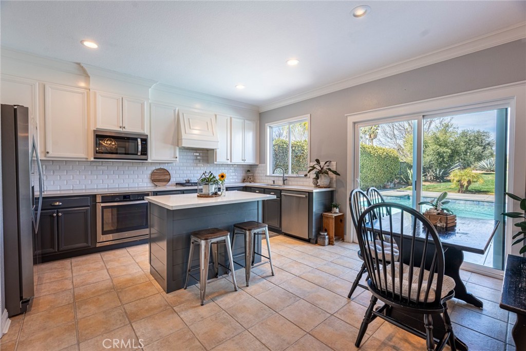 28201 Springvale Lane Castaic, CA 91384 - Photo 9 of 59 a kitchen with stainless steel appliances granite countertop a stove a sink a microwave a dining table and chairs