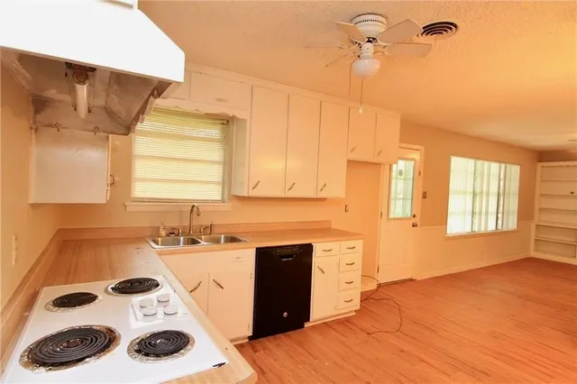 a kitchen with a sink a stove and cabinets