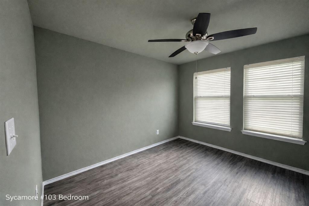 800 Sycamore Street, Unit 103 Commerce, TX 75428 - Photo 5 of 8 a view of an empty room with wooden floor and a window