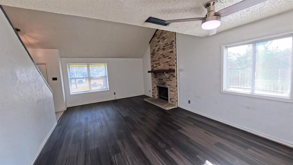 301 Gatewood Road Garland, TX 75043 - Photo 3 of 15 an empty room with wooden floor chandelier fan and windows