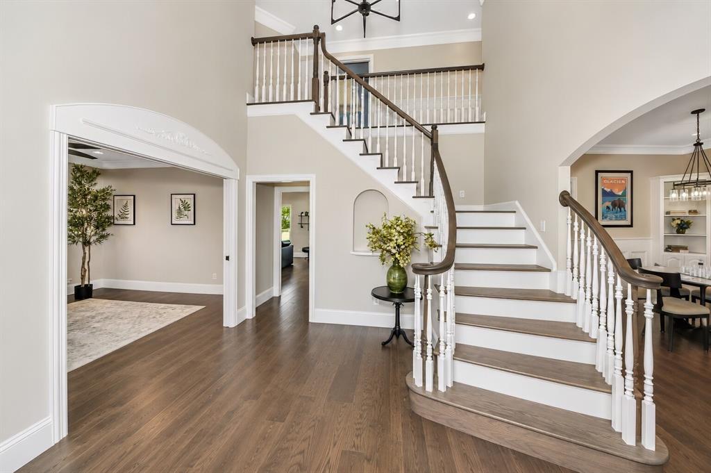 3817 Ganzer Road West Denton, TX 76207 - Photo 5 of 40 The foyer opens with a bright, easy flow, centered around the curved staircase and clean wood floors. Light moves through the space from every direction, giving the entry a calm, organized feel. The alcove under the stairs adds a simple touch of character, and each doorway leads into rooms that stay open and connected — a welcoming first impression that feels both modern and comfortable.