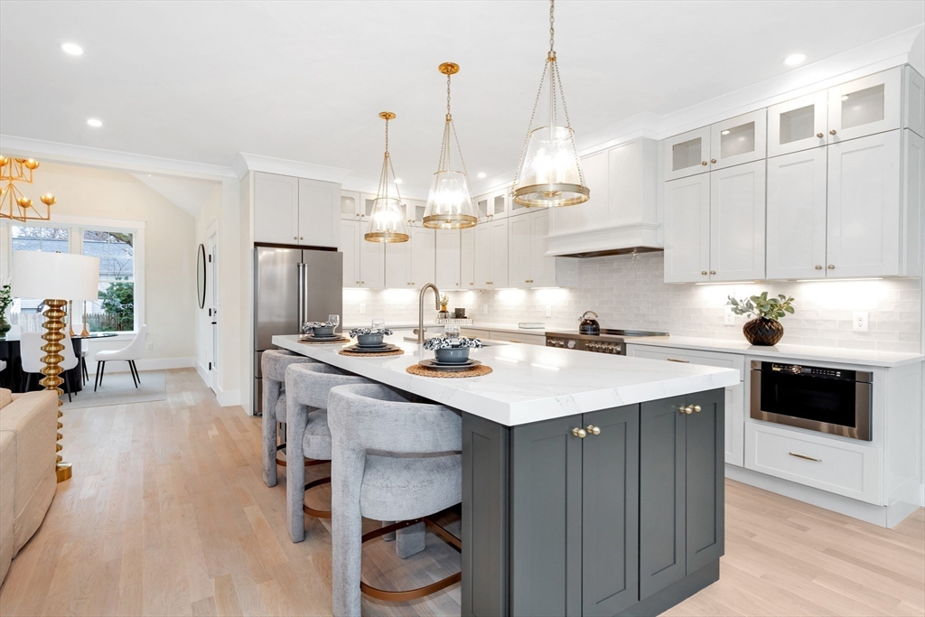 19 Cherokee Road Arlington, MA 02474 - Photo 4 of 42 a kitchen with kitchen island granite countertop a sink cabinets a refrigerator and a stove