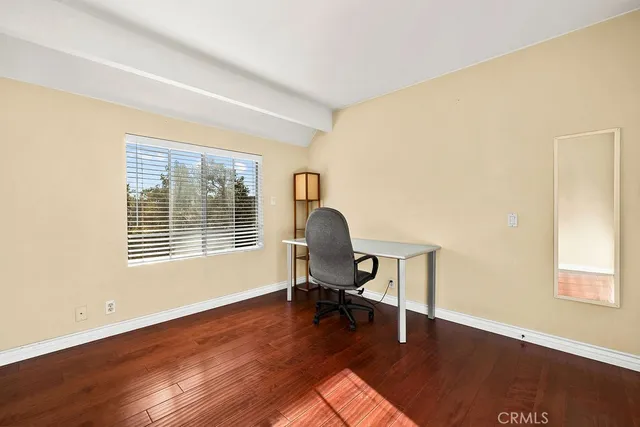 a view of a room with wooden floor and a window