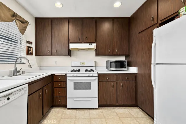 a kitchen with a refrigerator sink stove and cabinets