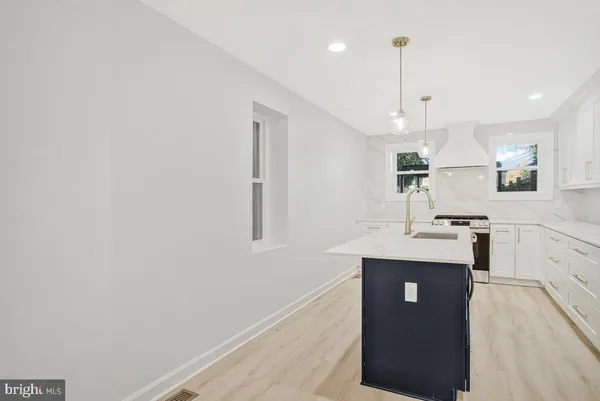 a kitchen with kitchen island a counter top space a sink and appliances