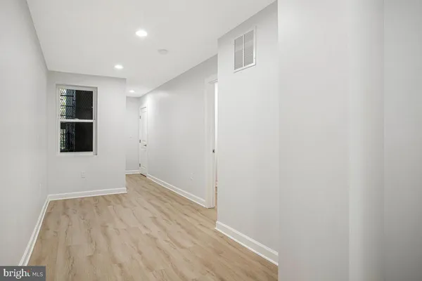 a view of a room with wooden floor and entryway