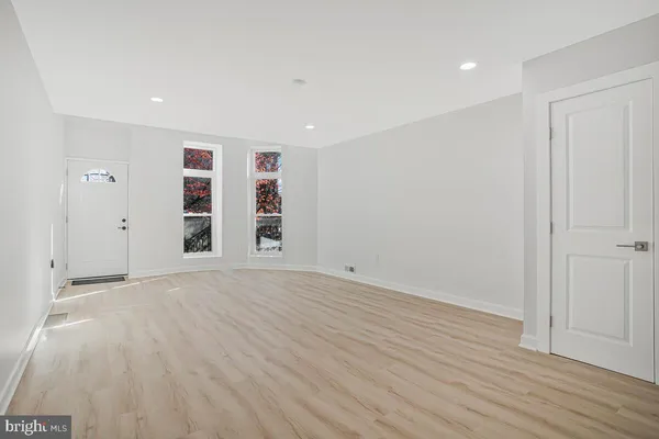 a view of empty room with wooden floor and window