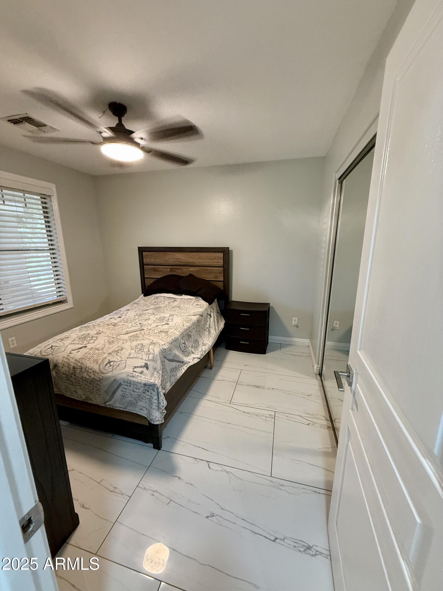 8534 West Cordes Road Tolleson, AZ 85353 - Photo 11 of 22 a bedroom with a large bed and a chandelier