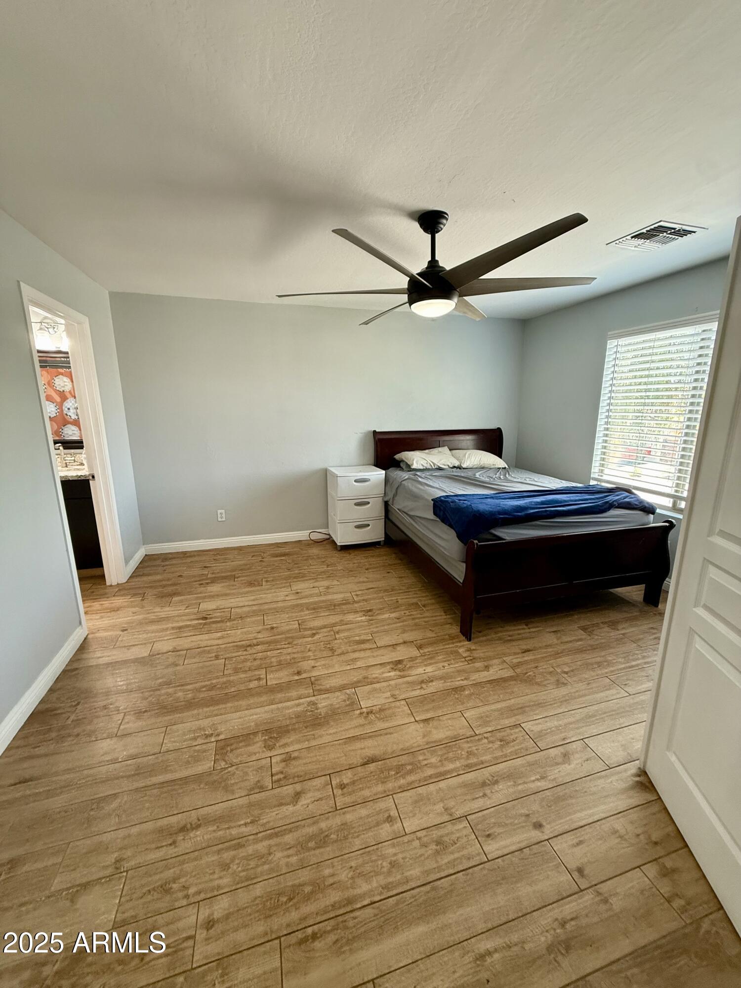 8534 West Cordes Road Tolleson, AZ 85353 - Photo 14 of 22 a room with a bed and a ceiling fan