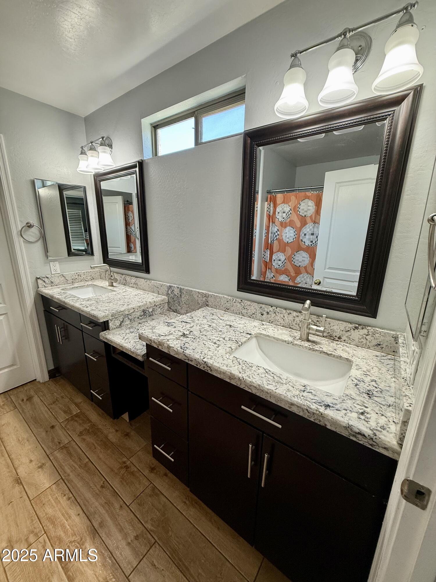 8534 West Cordes Road Tolleson, AZ 85353 - Photo 15 of 22 a bathroom with a granite countertop sink a mirror and vanity