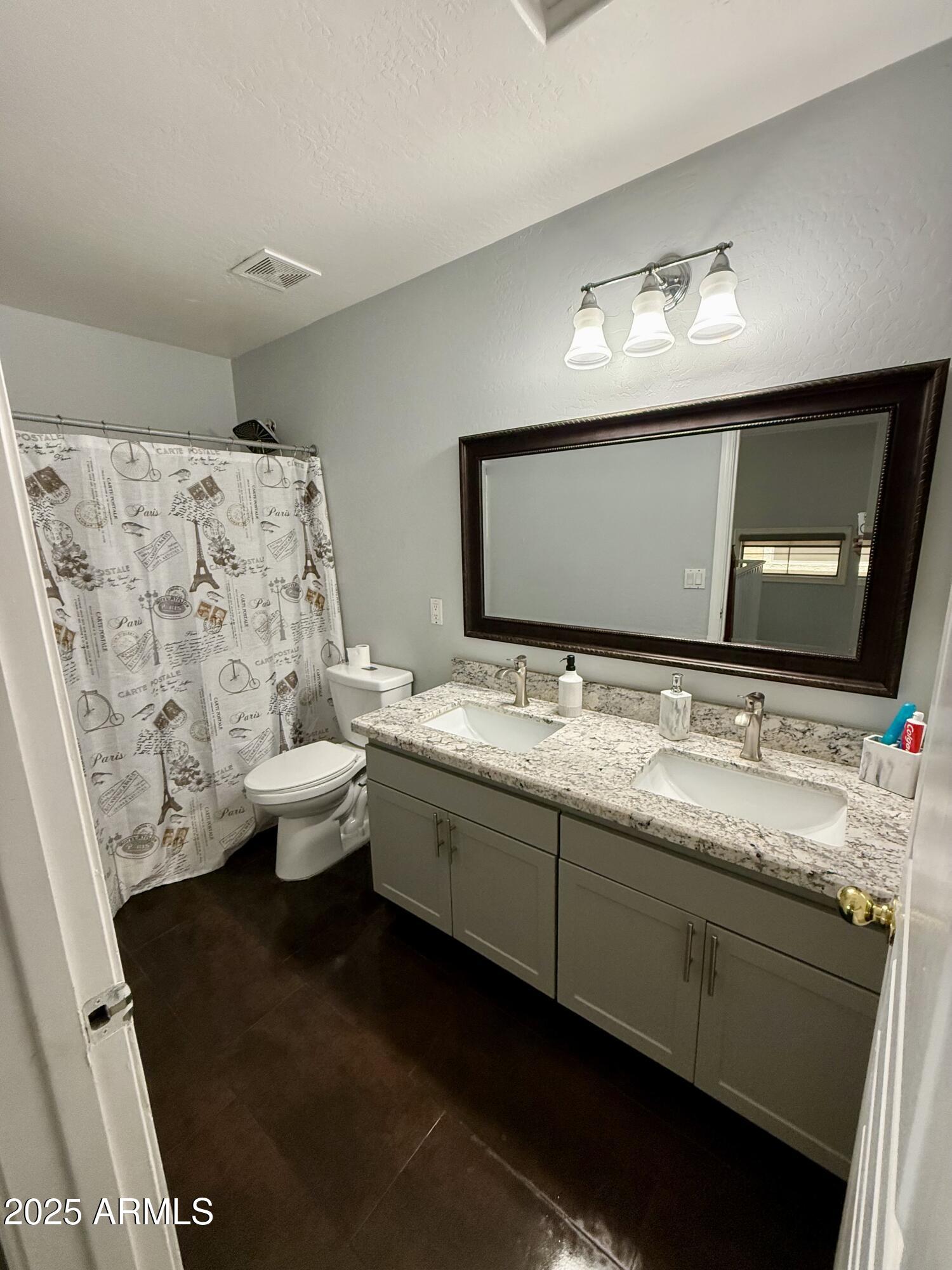 8534 West Cordes Road Tolleson, AZ 85353 - Photo 16 of 22 a bathroom with double sink and a mirror