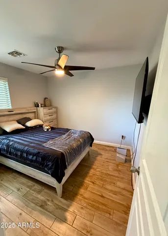 a spacious bedroom with a bed and a dresser