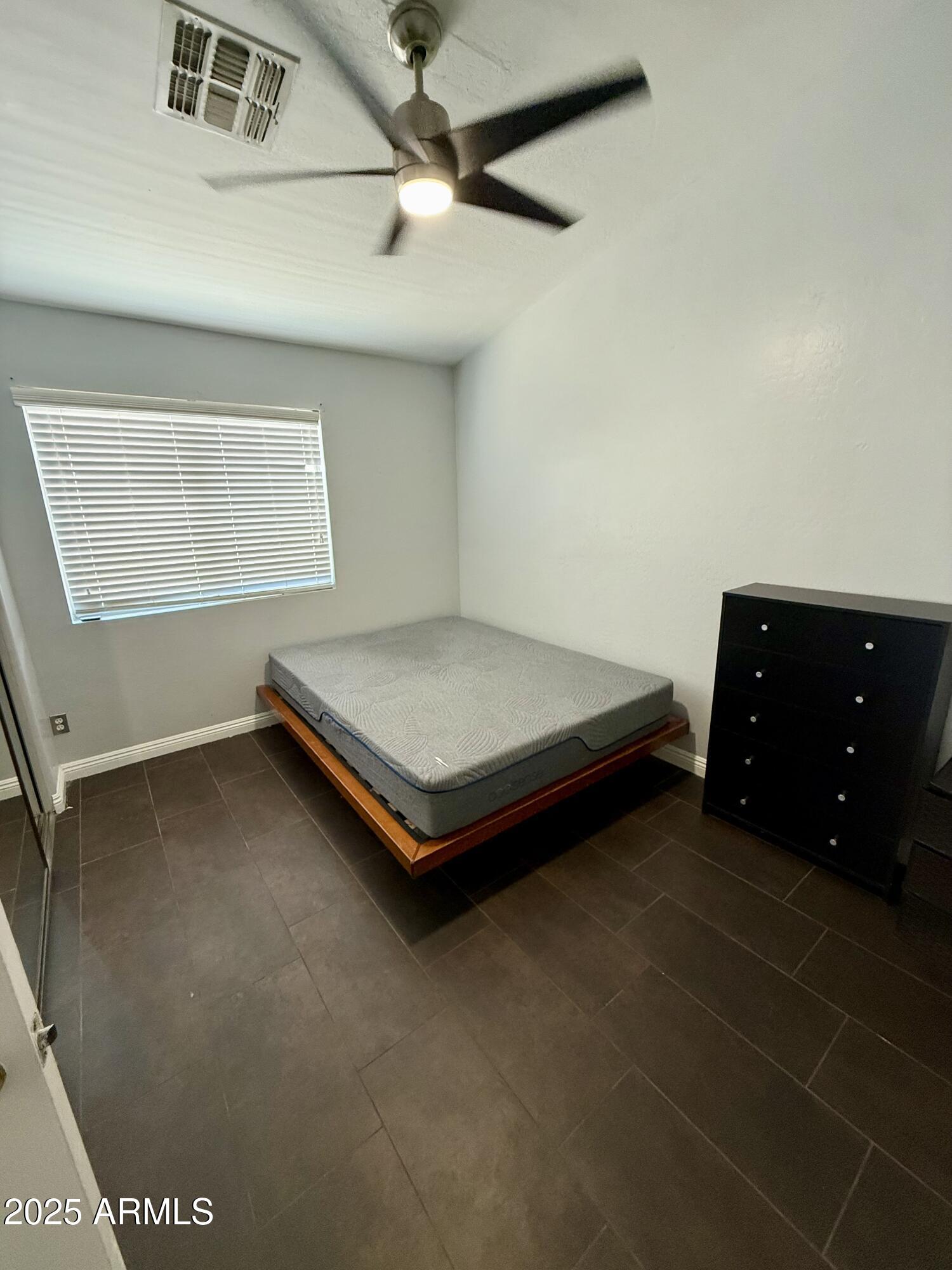 8534 West Cordes Road Tolleson, AZ 85353 - Photo 19 of 22 a spacious bedroom with a bed and a dresser