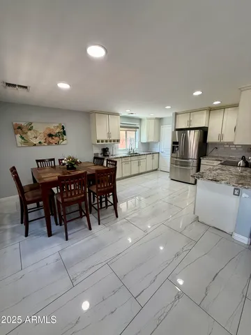 a kitchen with stainless steel appliances granite countertop a stove a sink and a refrigerator