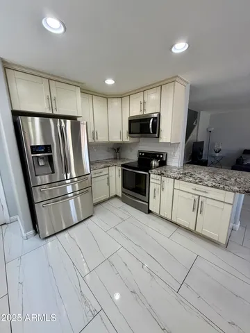 a kitchen with stainless steel appliances granite countertop a refrigerator sink and stove