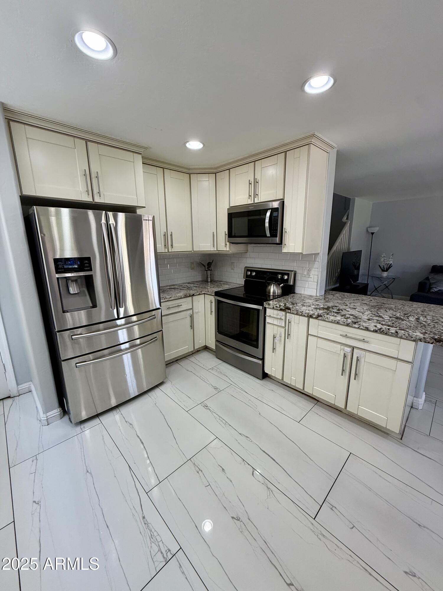 8534 West Cordes Road Tolleson, AZ 85353 - Photo 5 of 22 a kitchen with stainless steel appliances granite countertop a stove a sink and a refrigerator